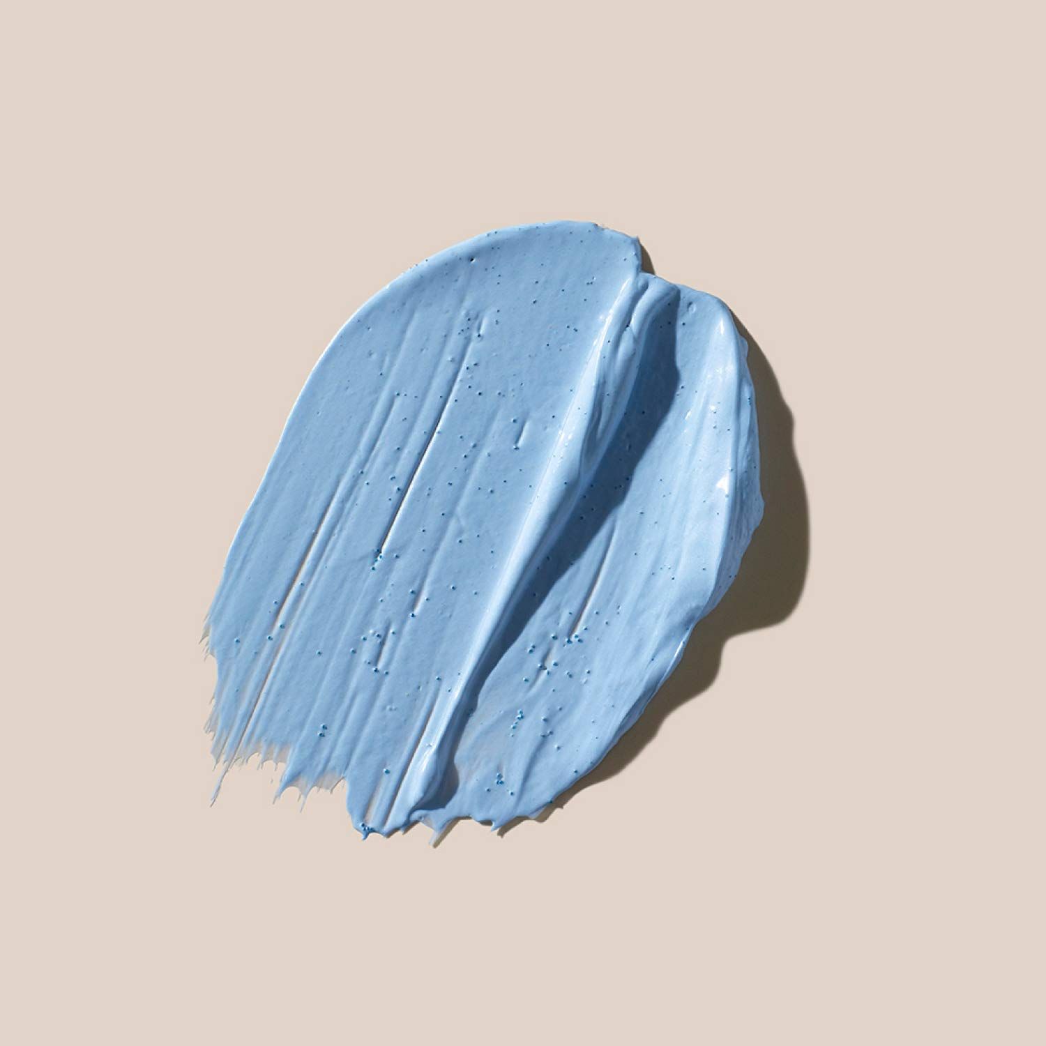 Blauer Produktstrich auf beigem Hintergrund. Textur sichtbar. Schatten.