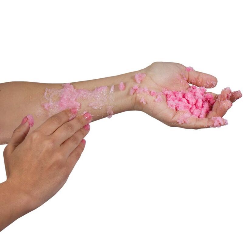 Rosa Badesalz auf Arm und Hand. Grobe Körnung. Hautkontakt.