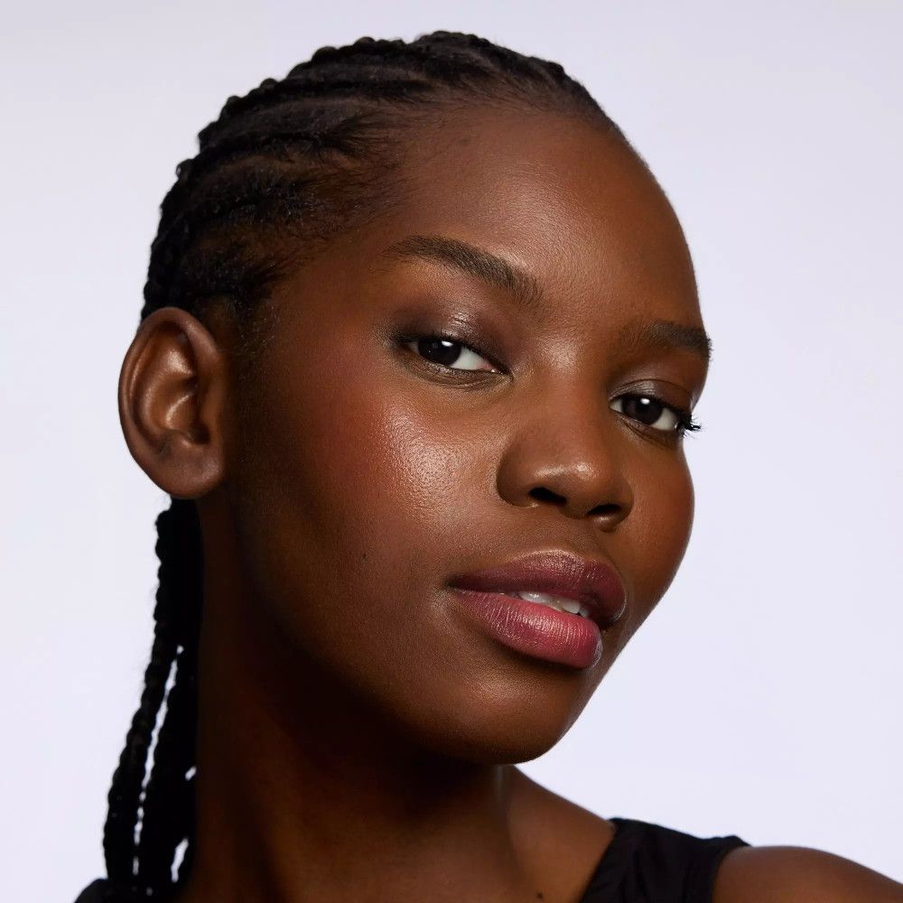 Dunkelhäutige Frau mit rosigen Wangen und Lippen. Natürliches Make-up.