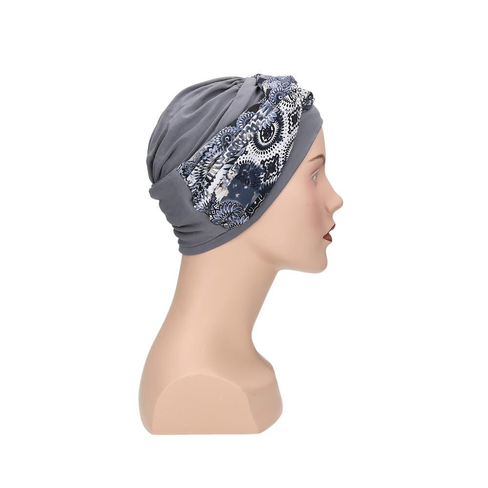 Grauer Turban mit floralem Muster. Auf einem Mannequin präsentiert. Seitenansicht.