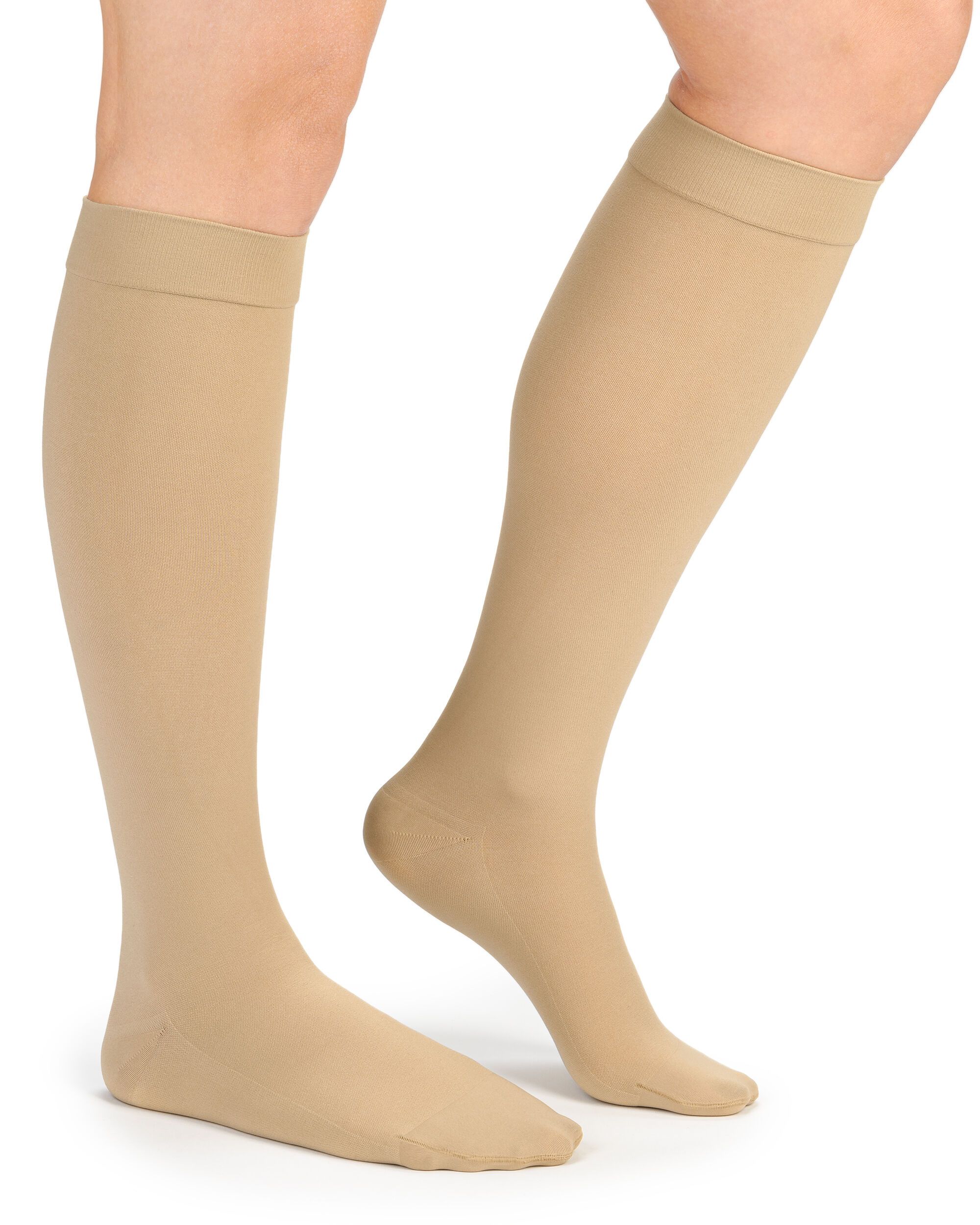Beige Kompressions-Kniestrümpfe an einer Person. Die Strümpfe bedecken den Fuß bis zum Knie.