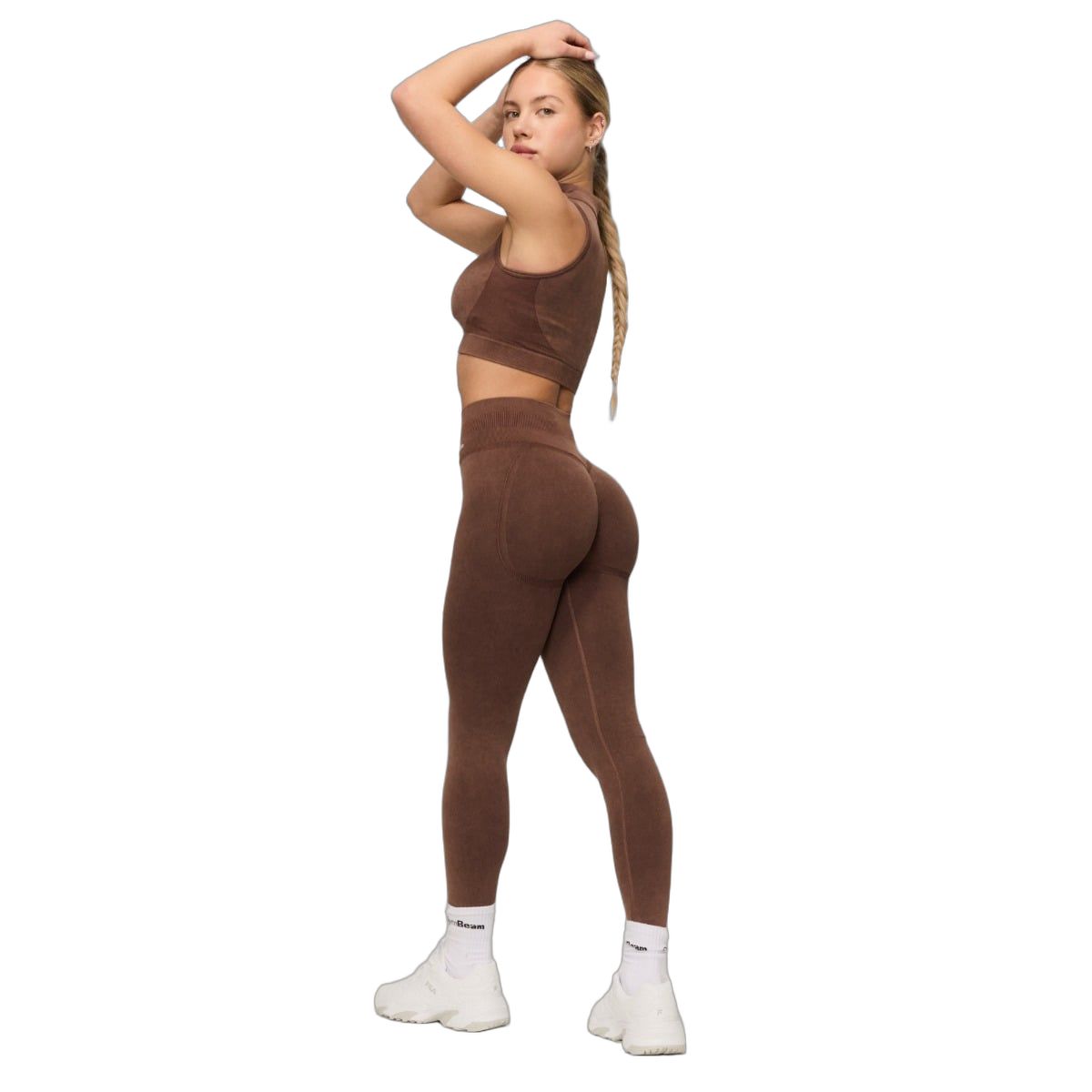 Seitliche Ansicht einer Frau in braunen, nahtlosen High-Waist-Leggings und passendem Top.