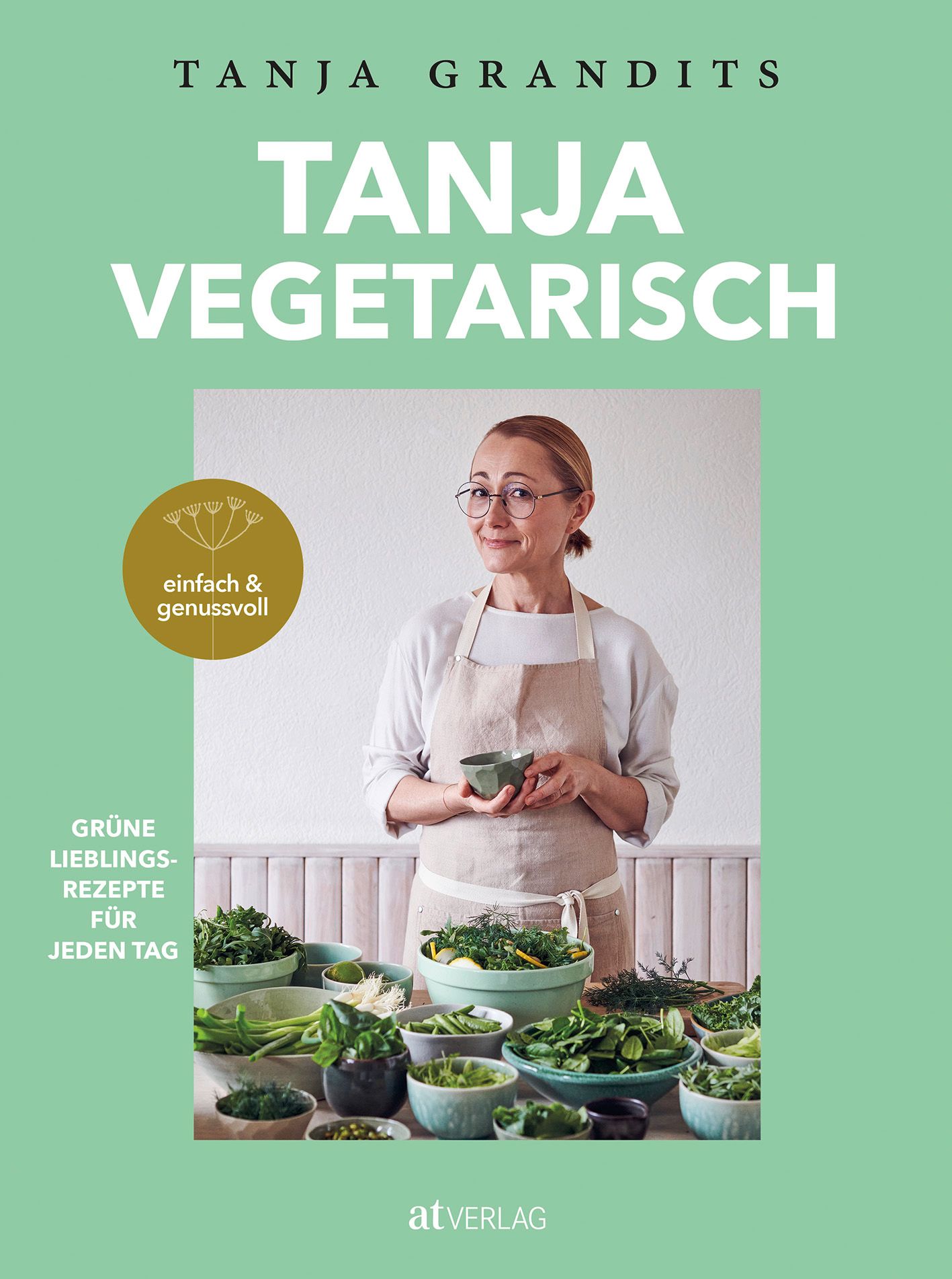 Buchcover: TANJA VEGETARISCH. Autorin Tanja Grandits. Frau mit Brille und Schürze, umgeben von Gemüse. Grünes Cover, weißer Titel.