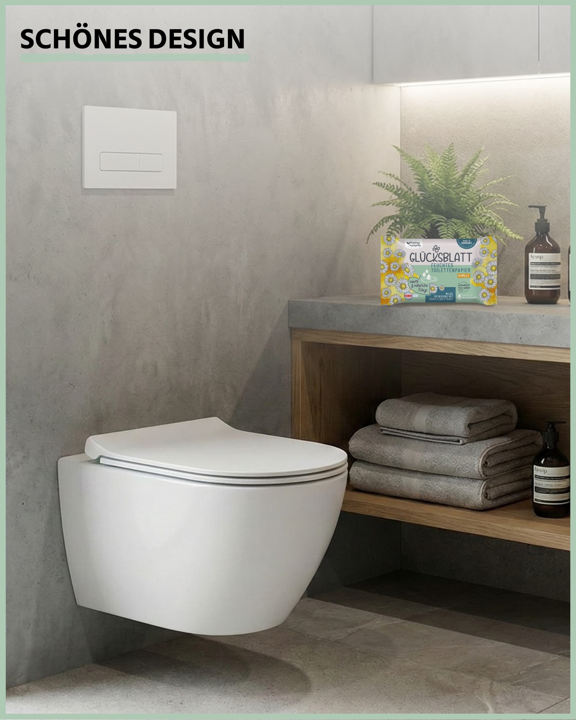 Badezimmer mit Toilette und Regal. Auf dem Regal: Feuchtes Toilettenpapier KAMILLE. Text: Glücksblatt. Pflanzen und Pflegeprodukte.