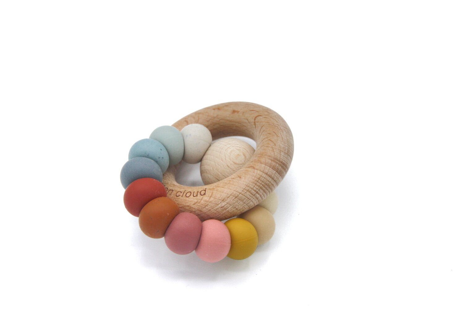 Beißring aus Holz mit farbigen Perlen. Ringförmig, mit einem Holzring und farbigen Kugeln. Auf dem Holzring ist "cloud" eingraviert.