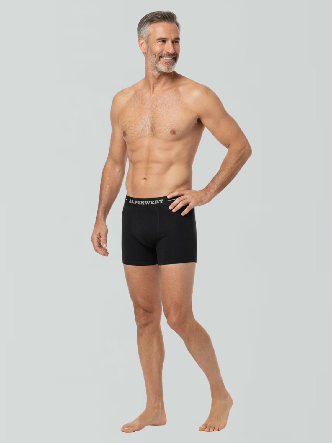 Mann in schwarzen Boxershorts aus Merinowolle mit ALPENWERT-Bund, Seitenansicht.