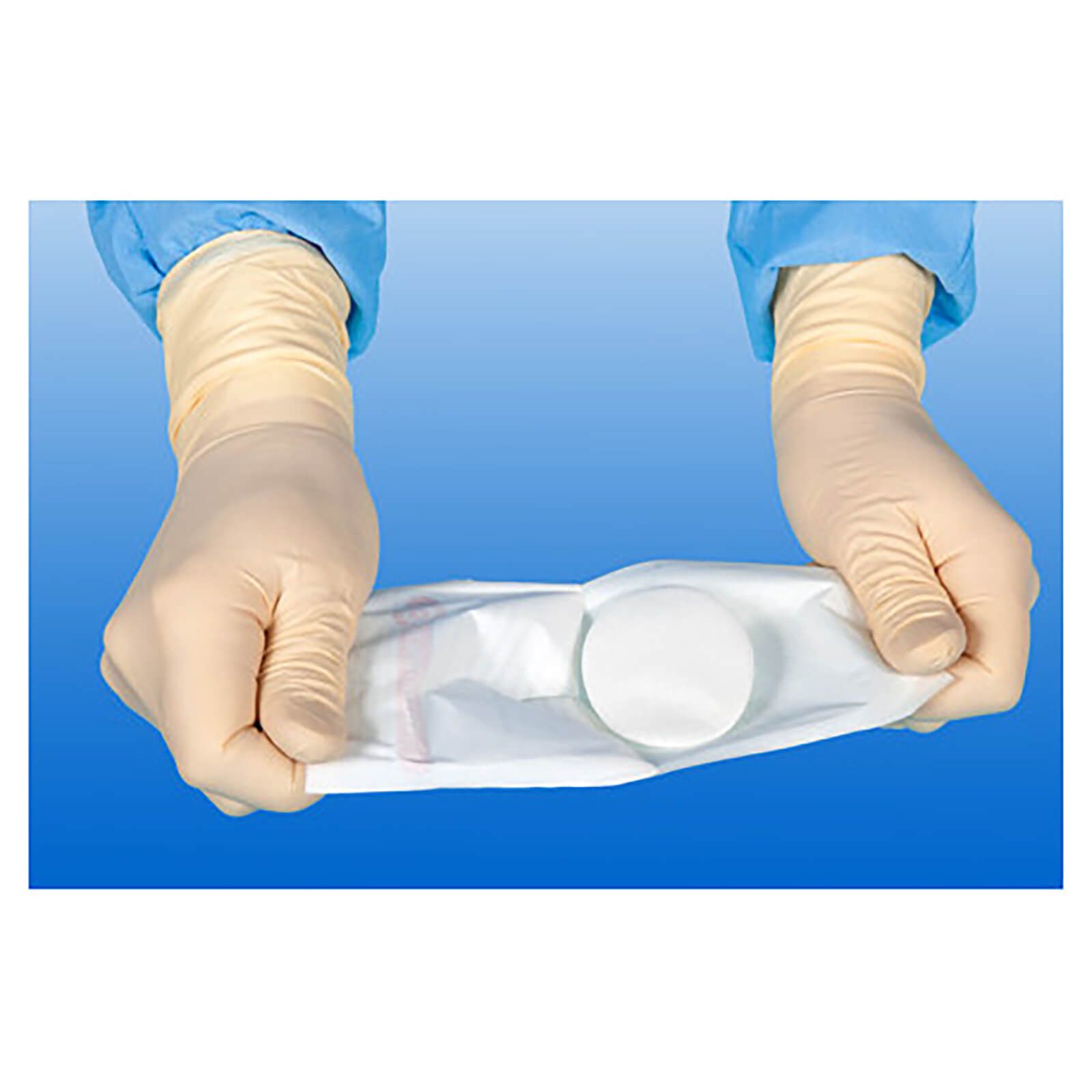 Hände in Handschuhen halten eine Verpackung mit einer Augenkompresse. Die Verpackung ist transparent.