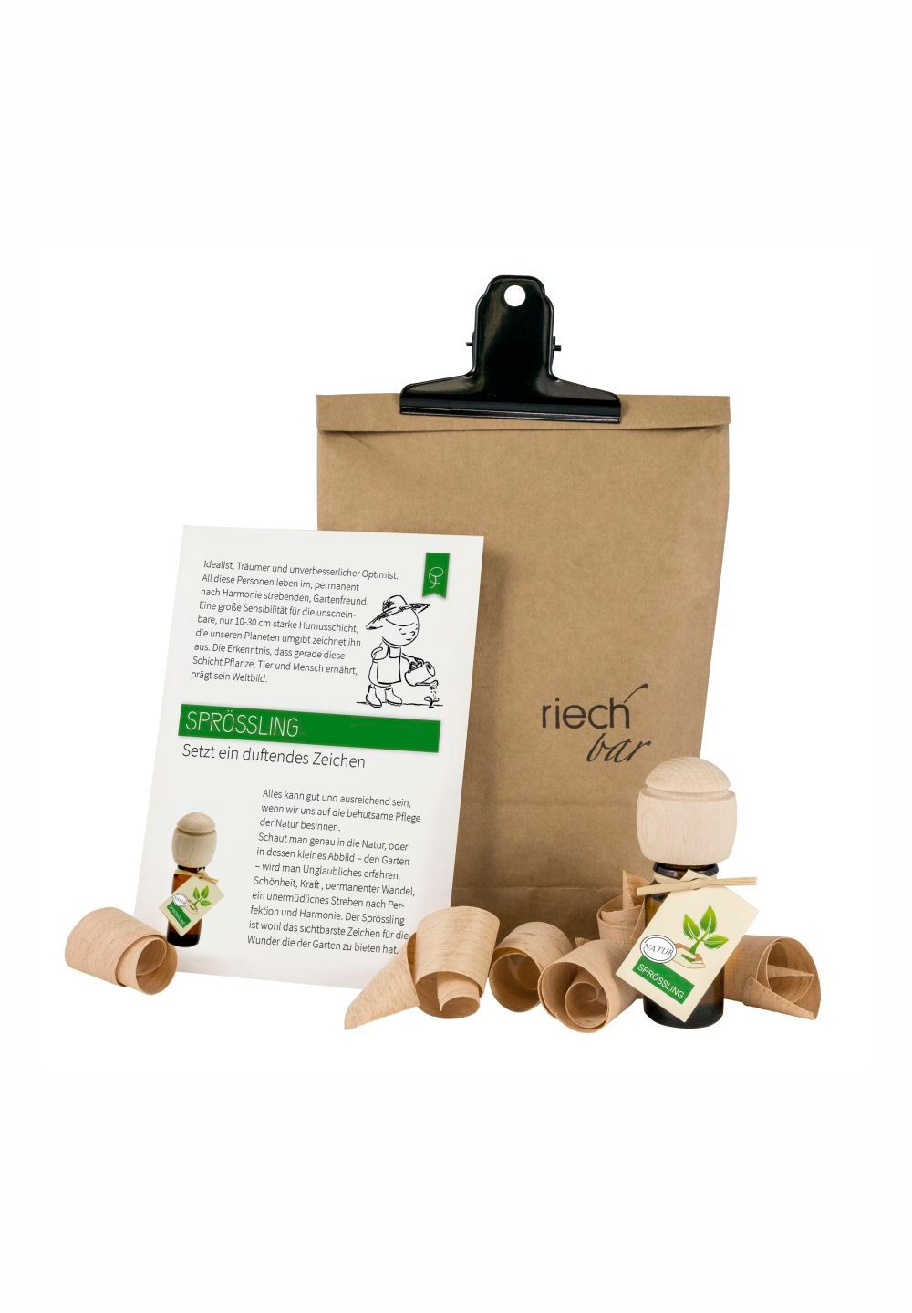 Geschenkset mit Papiertüte, Holzfigur, Duftflasche und Holzspänen. Aufschrift: "riech bar" und "Sprossling".