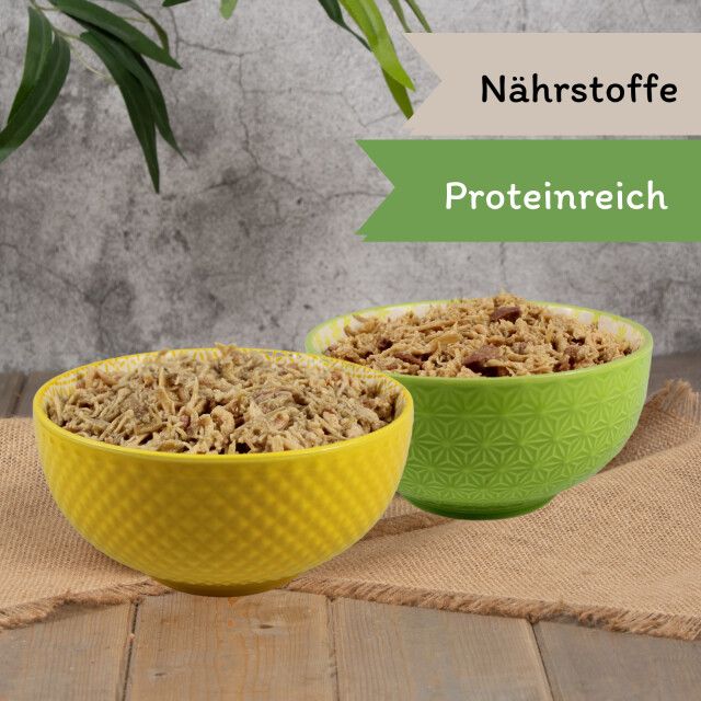 Zwei Schalen Katzenfutter. Beschriftung: Proteinreich. Gelbe und grüne Schalen. Aufschrift: Nährstoffe.