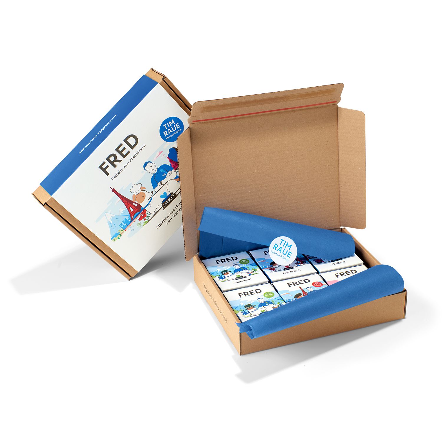 Geöffnete Versandbox mit FRED-Produktverpackungen. Einzelne Boxen mit Illustrationen und Text. Ein Aufkleber mit Logo.