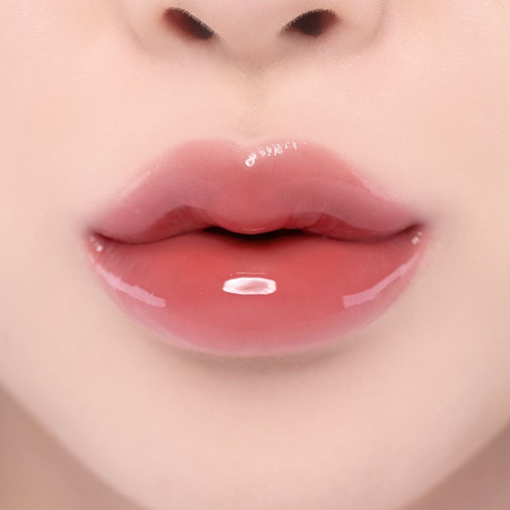 Nahaufnahme von vollen, glänzenden Lippen mit einem rosafarbenen Lipgloss.