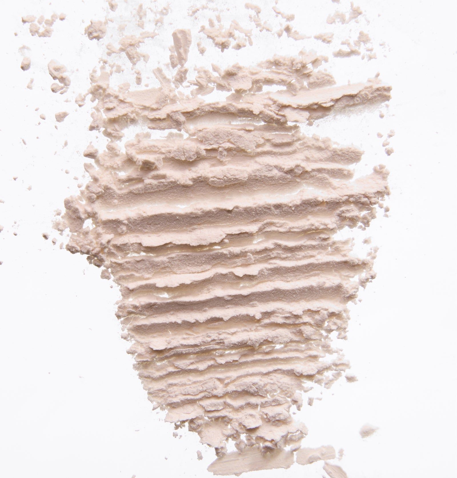 Nahaufnahme von hellbraunem Trockenshampoo-Puder auf weißem Hintergrund.