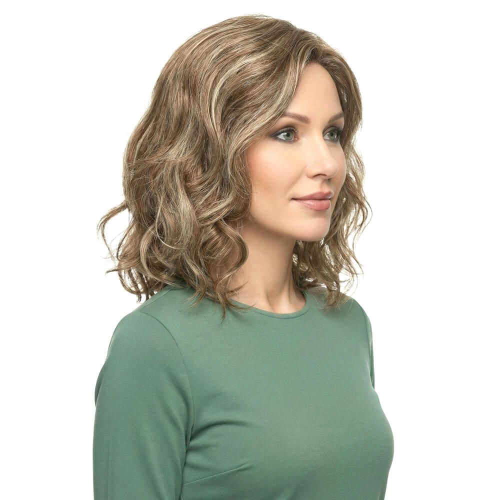 Perücke mit gewelltem, blond-braunem Haar. Frau trägt ein grünes Oberteil. Dreiviertelansicht.