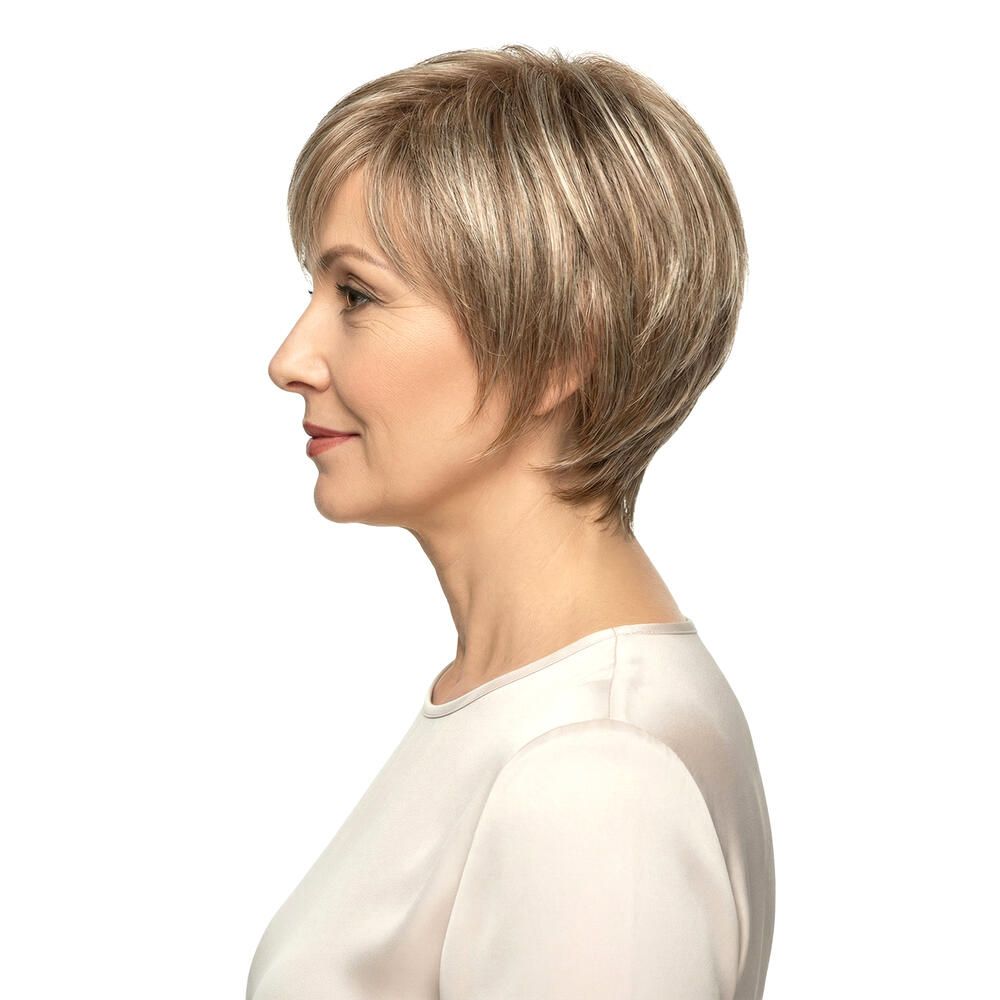 Kurzhaarperücke mit Pony. Blond-braune Haarfarbe. Frau mit Perücke, Profilansicht.