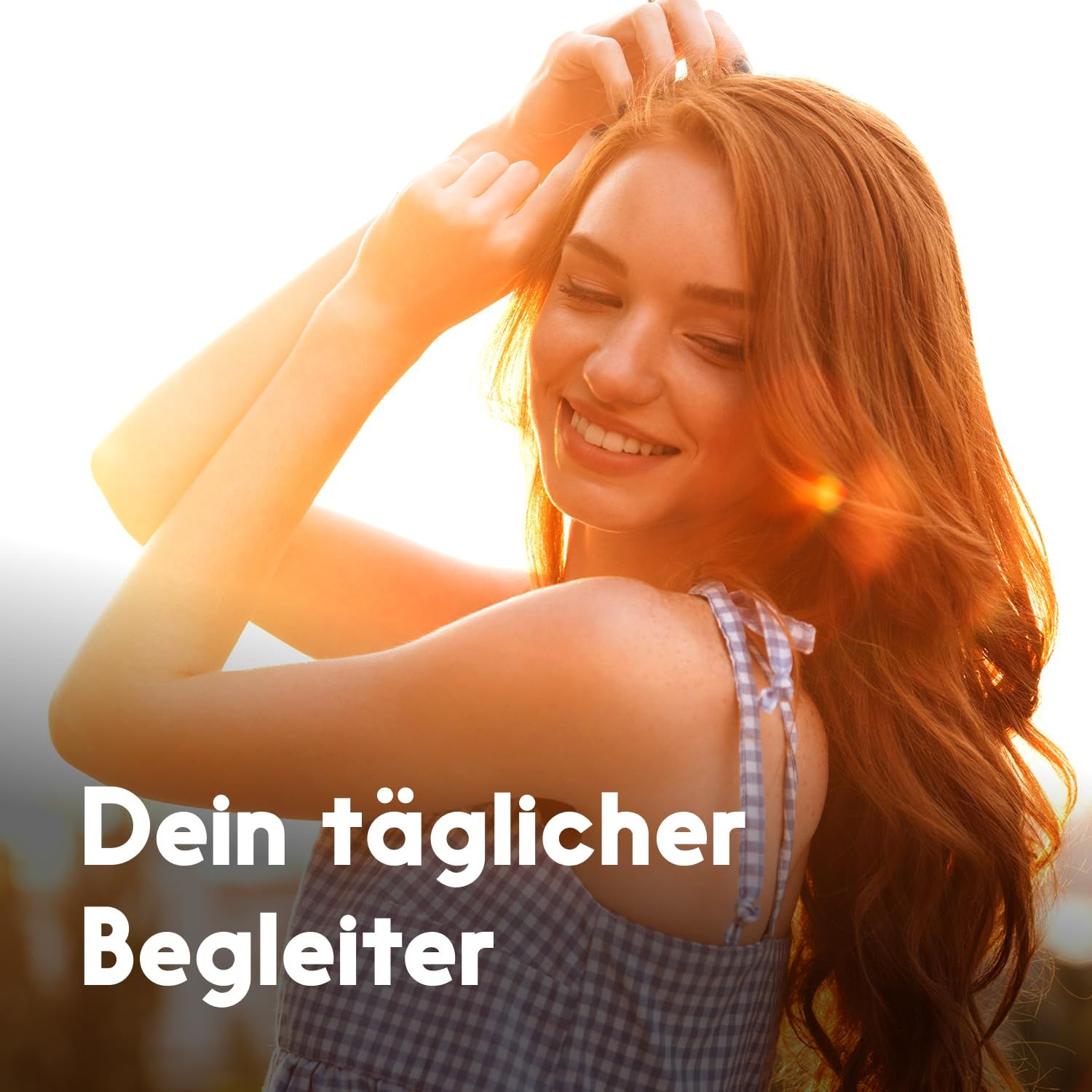Junge Frau mit langen roten Haaren, lächelnd im Sonnenlicht. Text: Dein täglicher Begleiter.