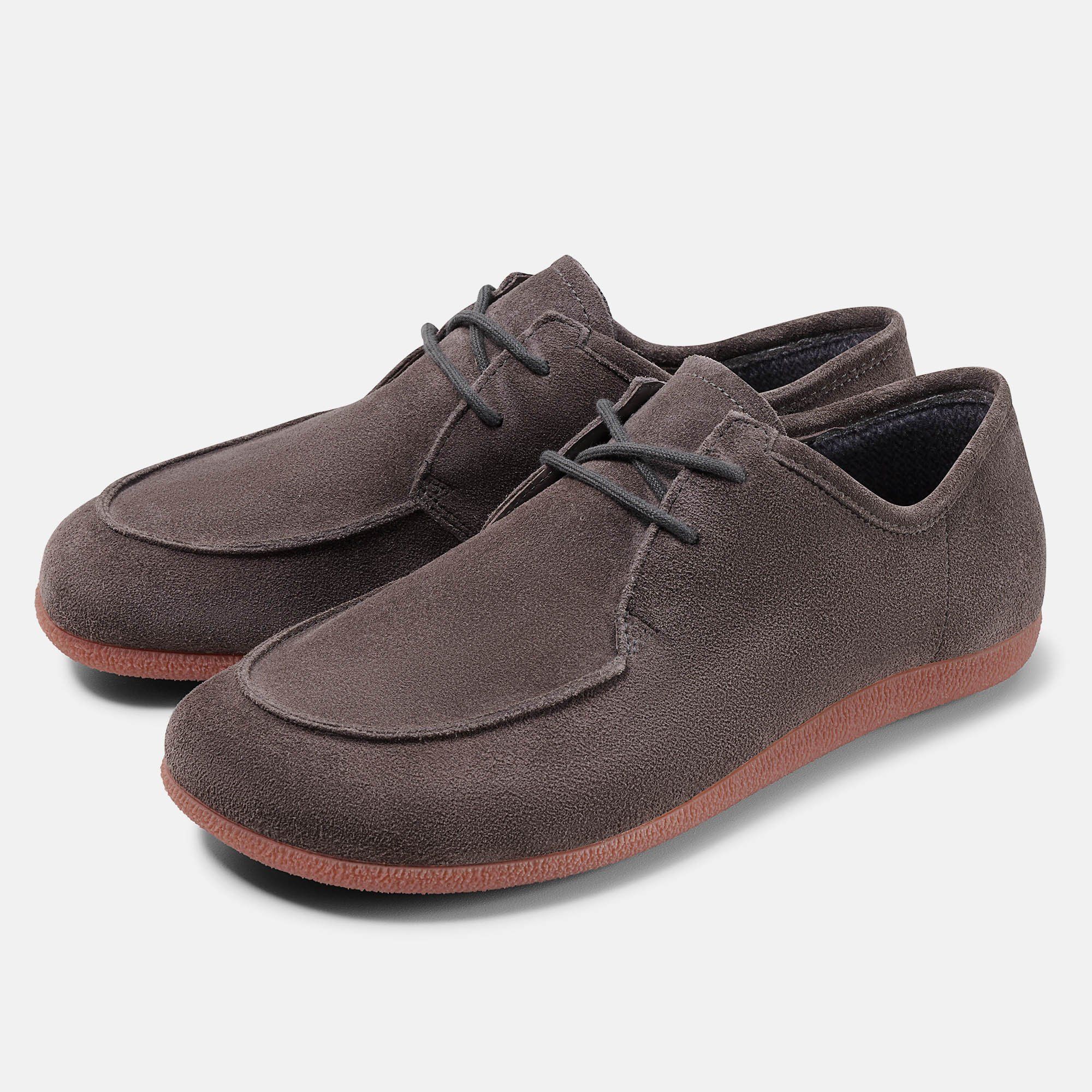 Zwei braune Schnürschuhe mit runder Spitze und roter Sohle. Obermaterial aus Wildleder.