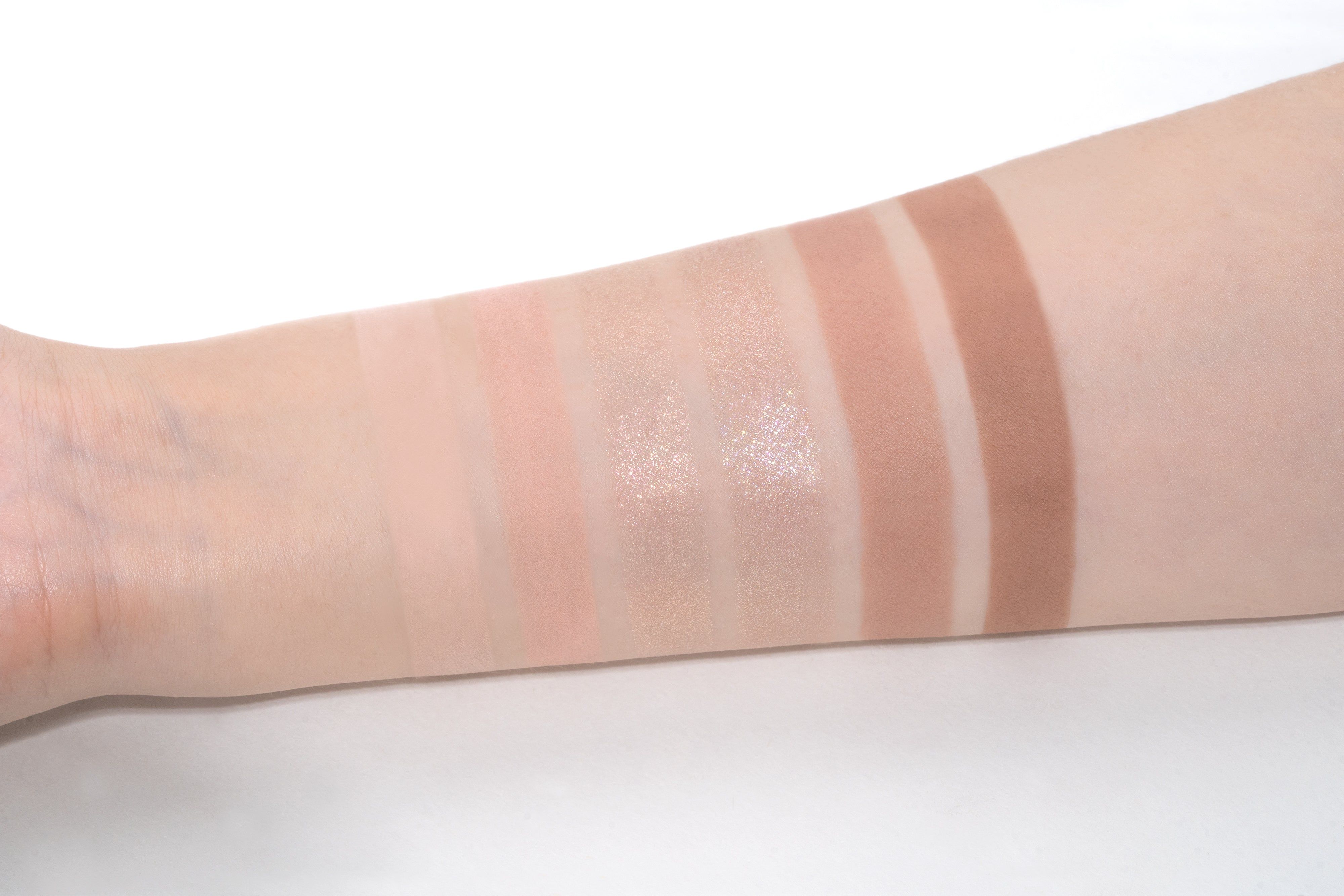 Arm mit sechs Lidschatten-Swatches in verschiedenen Nude-Tönen.