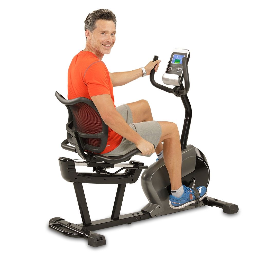 Mann sitzt auf einem Ergometer. Er trägt Sportkleidung. Das Gerät hat ein Display.