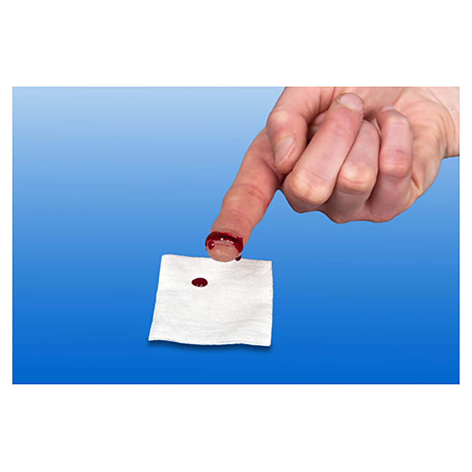Finger mit Blutung, daneben Mullkompresse mit Blutfleck. Hintergrund blau.