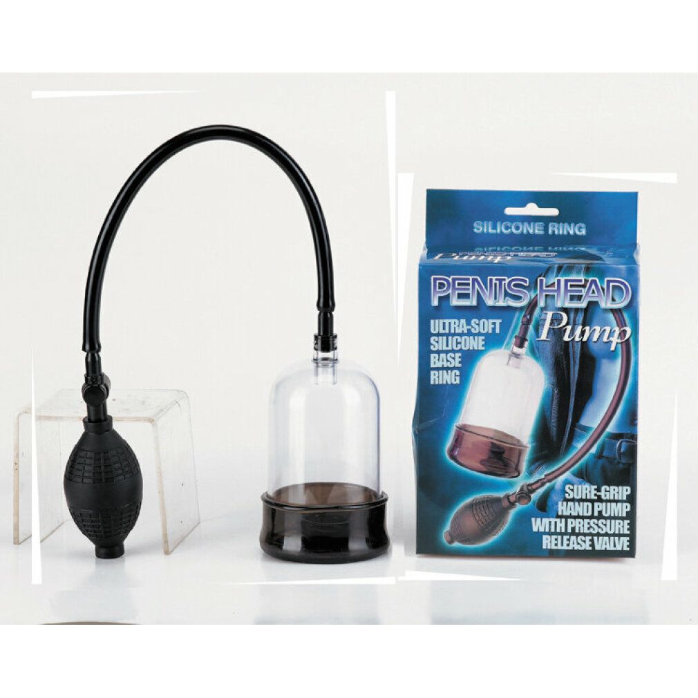 PENIS HEAD Pump. Transparenter Zylinder, schwarzer Schlauch und Handpumpe. Schwarzer Sockel. Handpumpe mit geriffelter Oberfläche. Verpackung daneben.