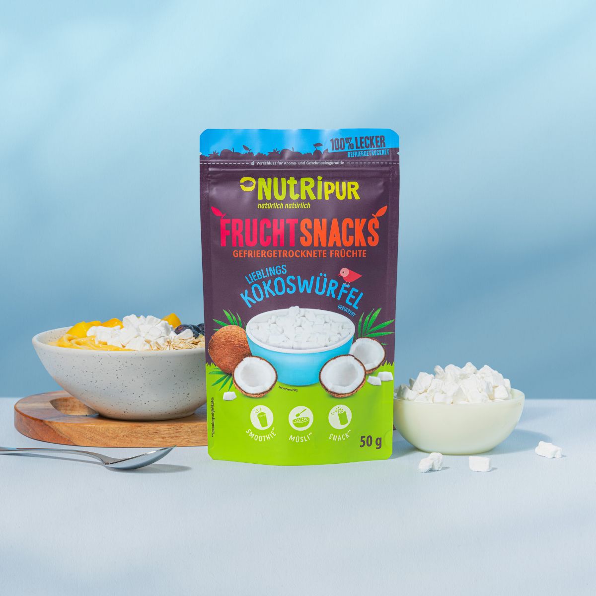 Verpackung NutriPur Frucht Snacks Kokoswürfel. Schüssel mit Obst und Kokoswürfeln. Kleine Schale mit Würfeln.