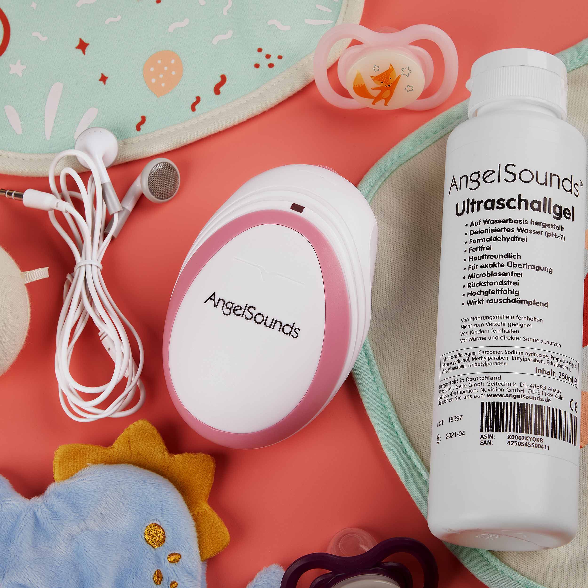 Fetal-Doppler, Ultraschallgel, Schnuller, Lätzchen und Kopfhörer auf rosa Untergrund. AngelSounds.