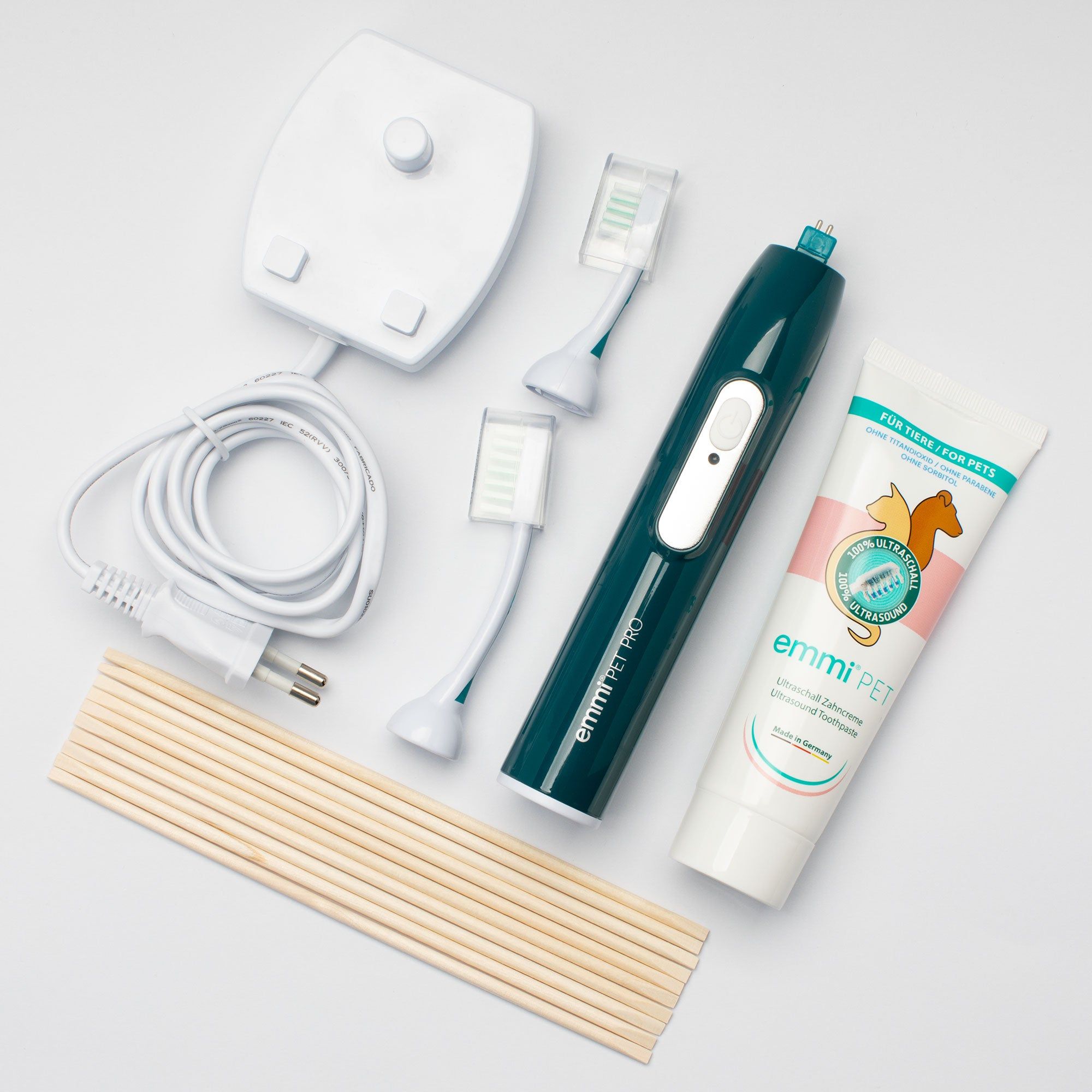 Set mit Ultraschall-Zahnbürste, Ladestation, Zahnbürstenköpfen, Zahnpasta und Holzstäbchen. Das Set ist für Haustiere bestimmt.