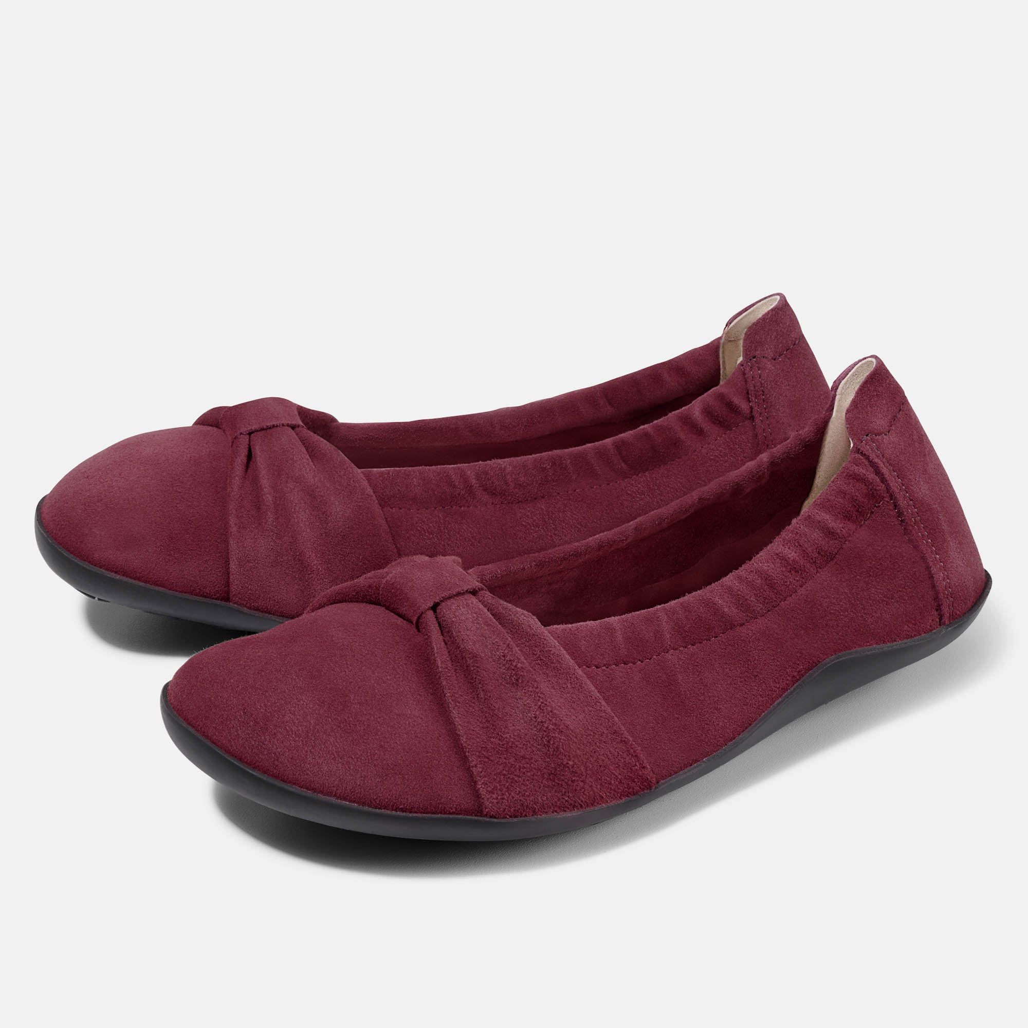 Zwei weinrote Ballerinas. Obermaterial aus Wildleder, Schleife auf dem Vorderfuß. Schwarze Sohle. Weite Form.