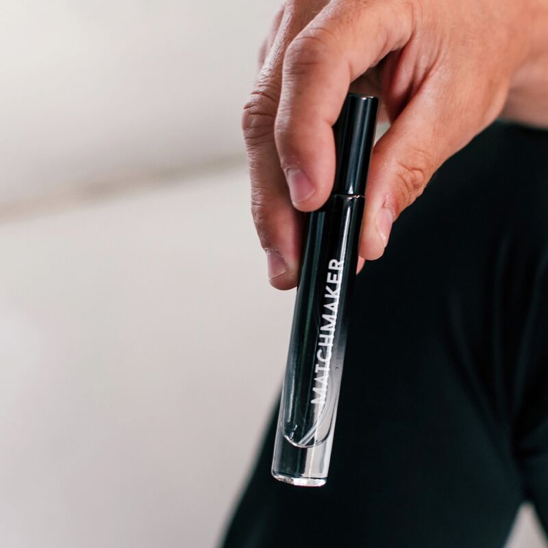 Hand hält eine schwarze Flasche mit weißem Schriftzug MATCHMAKER. Der Flakon ist halb gefüllt.