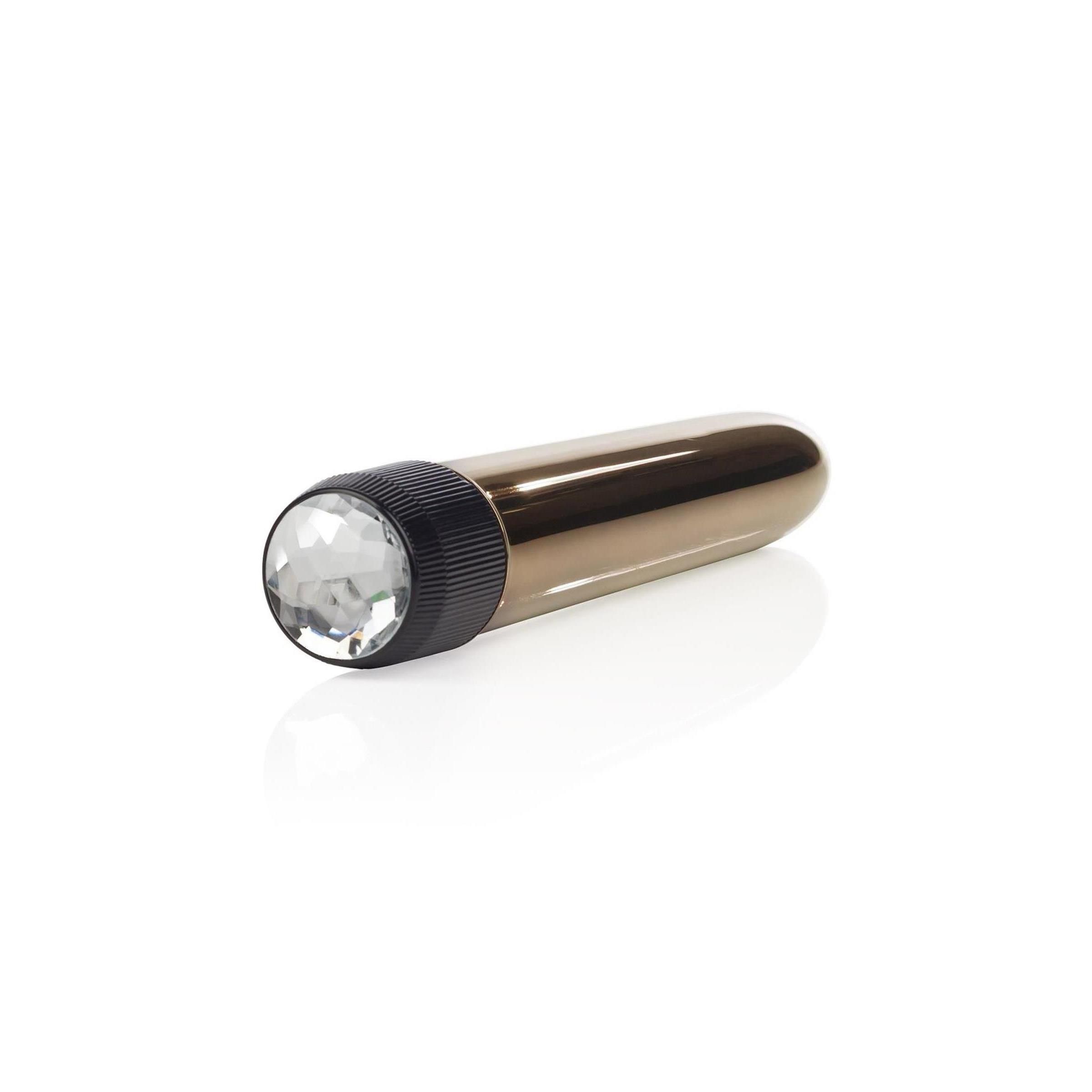 Goldfarbener Vibrator mit schwarzem Ende und Kristallbesatz. Auf weißem Hintergrund.