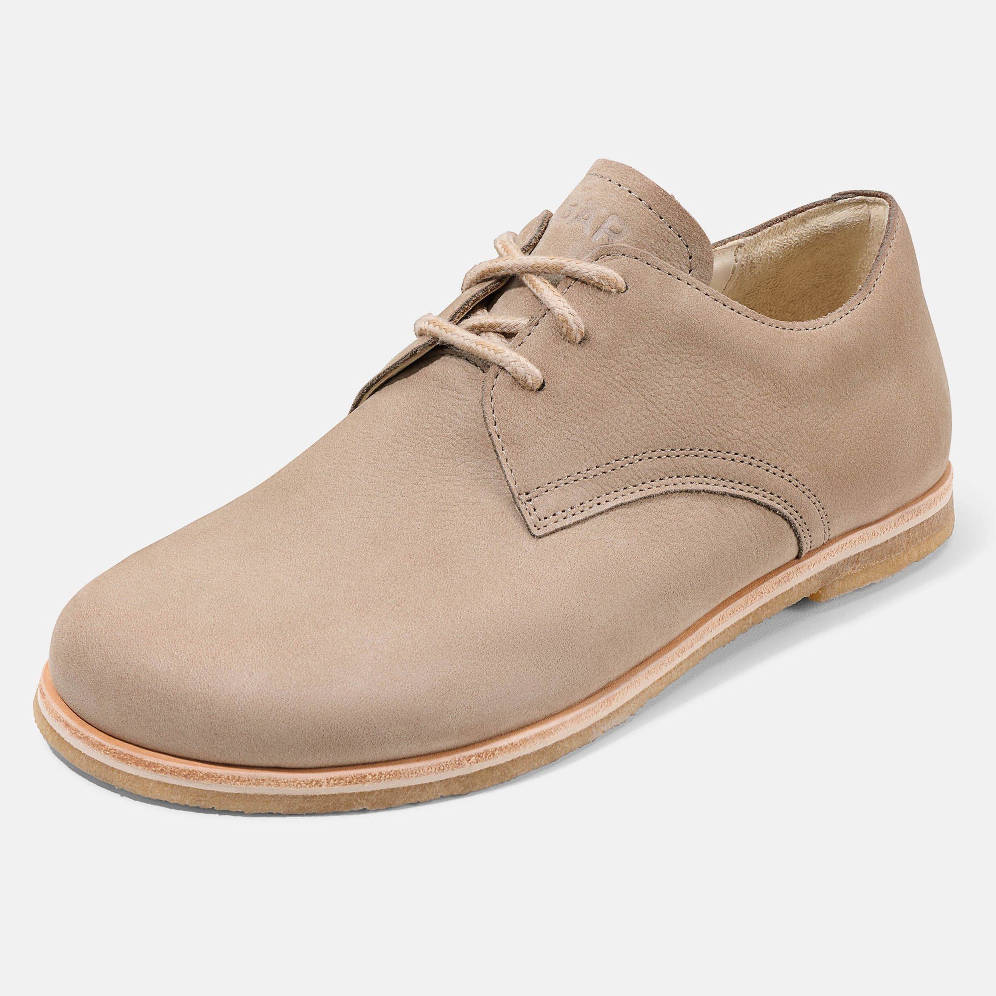 Beigefarbener Schnürschuh. Flache Sohle, helle Schnürsenkel. Schräge Ansicht.