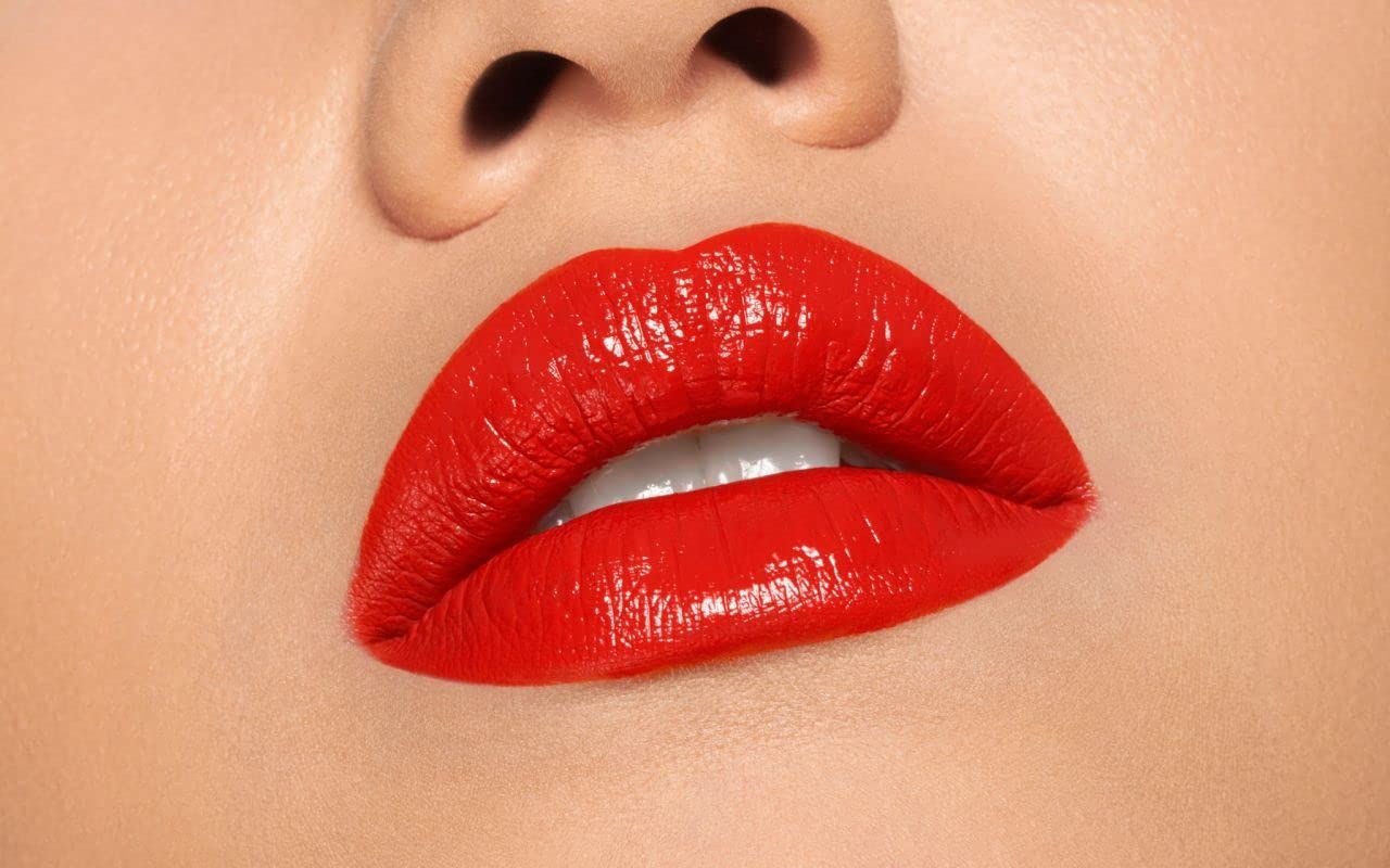 Nahaufnahme von roten Lippen. Die Lippen sind glänzend und voll. Ein Teil der Nase ist sichtbar.