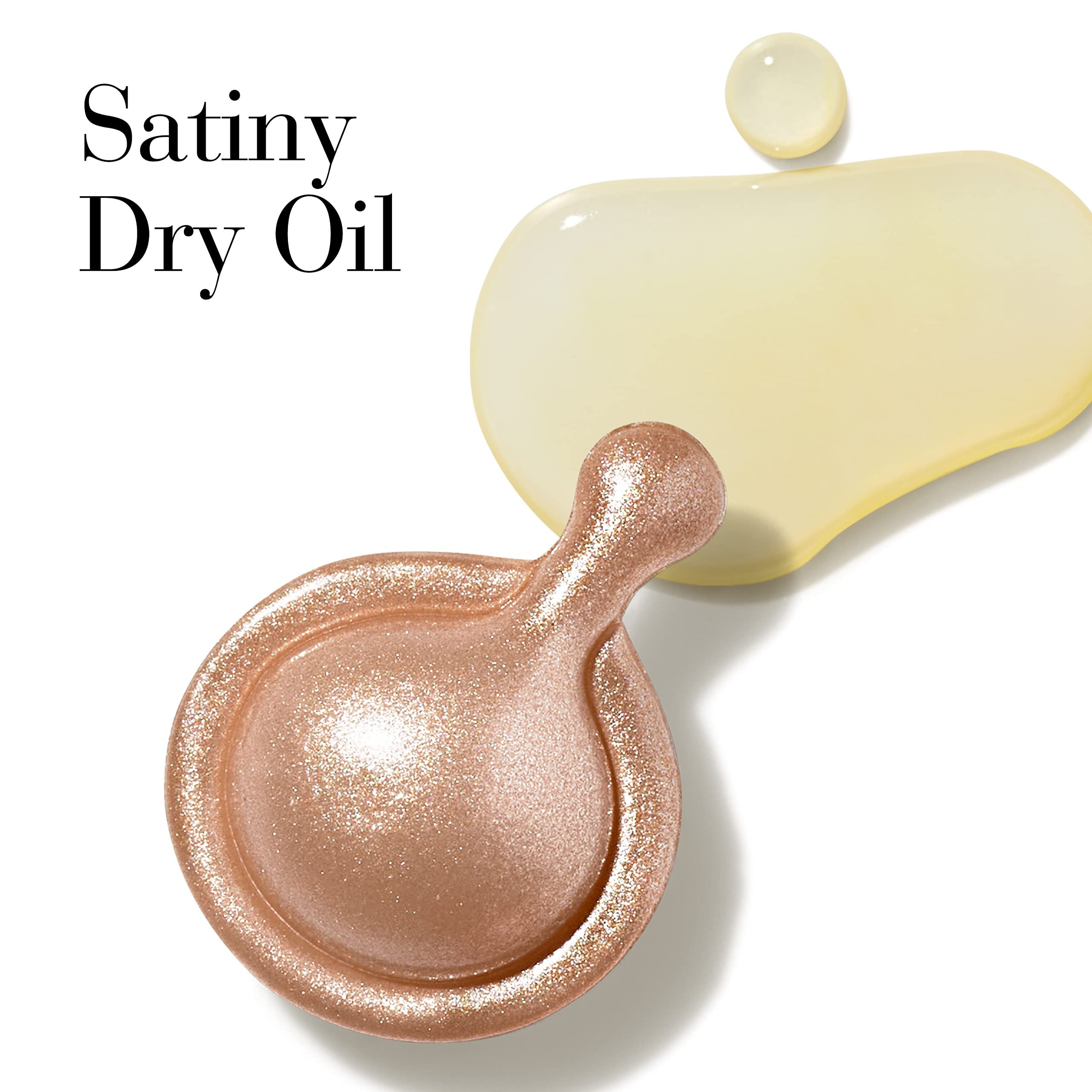 Nahaufnahme einer goldenen Kapsel und Öltröpfchen. Text: Satiny Dry Oil.