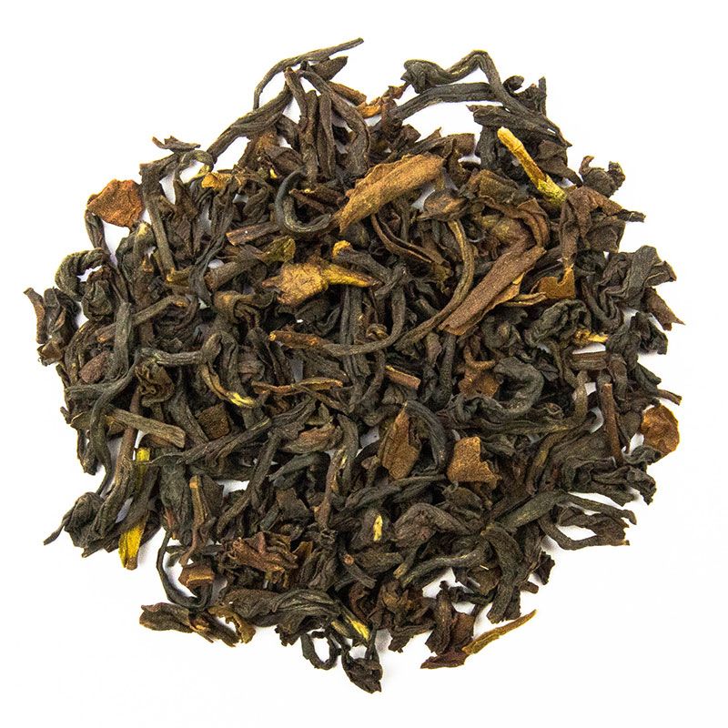 Trockene, lose Teeblätter. Dunkelbraune Farbe mit gelblichen Akzenten. Nahaufnahme, Draufsicht.