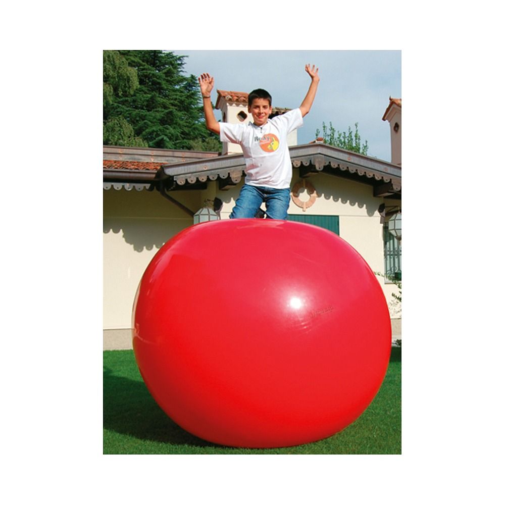 Roter Gymnic Megaball 180. Ein Junge steht auf dem Ball. Der Ball ist groß und rund. Im Hintergrund ein Haus und Rasen.