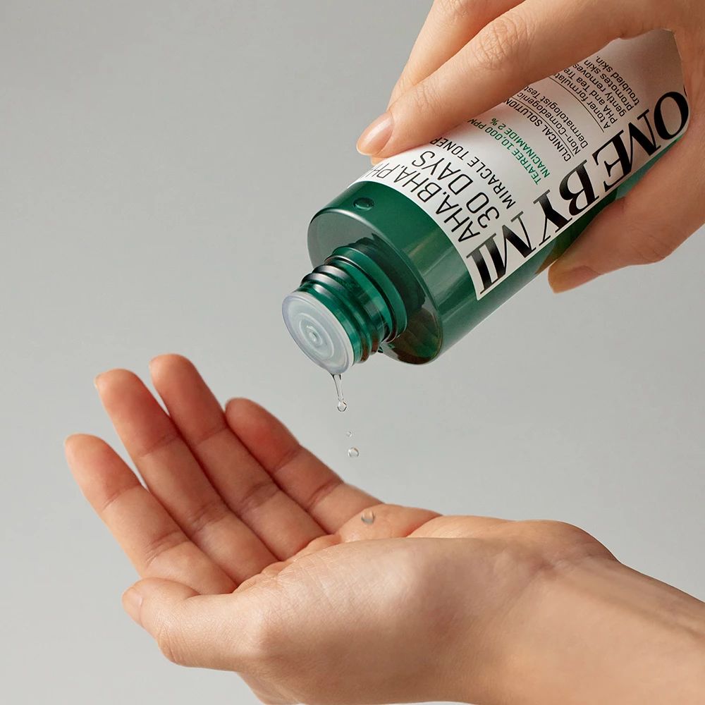 Grüne Flasche wird in eine Hand gegossen. Aufschrift: AHA-BHA-PHA 30 DAYS MIRACLE TONER. SOME BY MI.