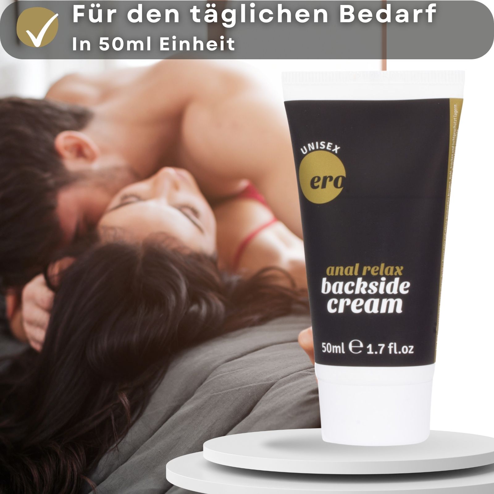 Creme-Tube und Text. Aufschrift: "Ero", "anal relax backside cream". Schwarzer Tube, goldfarbene Schrift. Paar im Hintergrund.