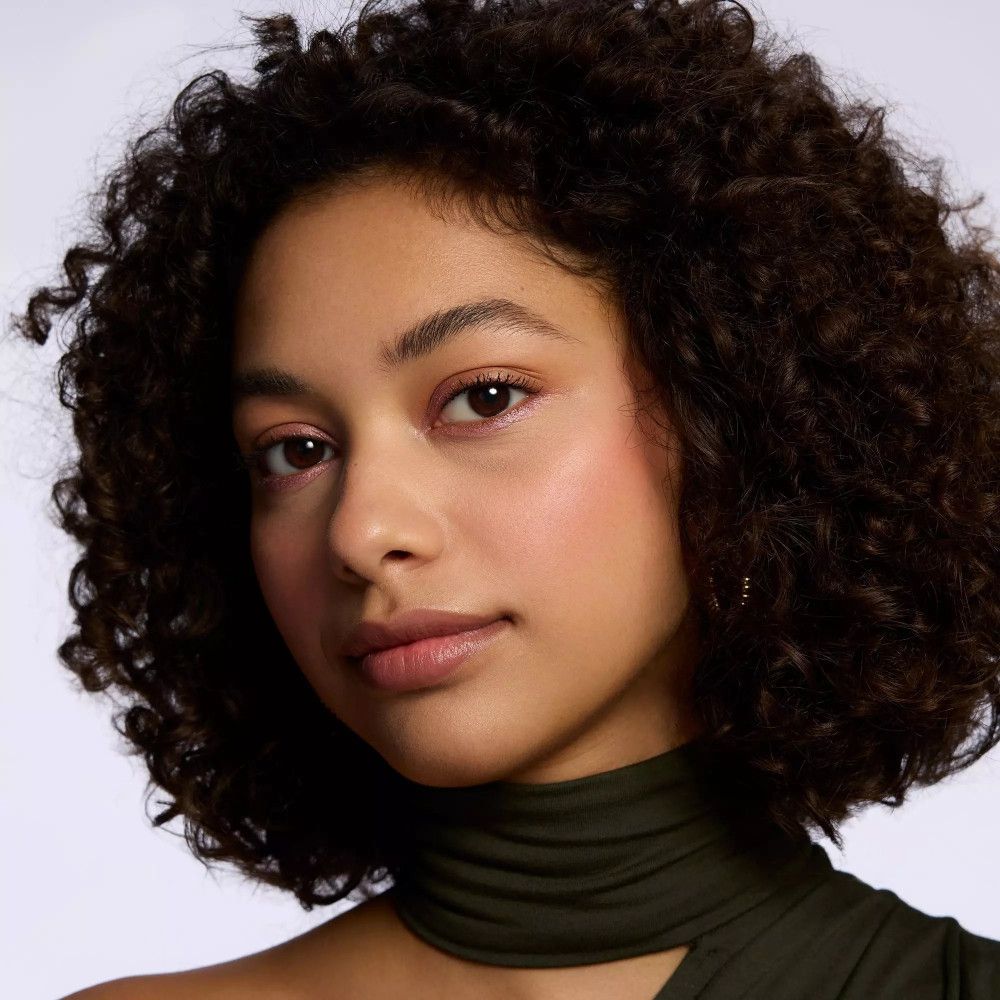 Porträt einer Frau mit rosa Lidschatten. Hautton, Locken.