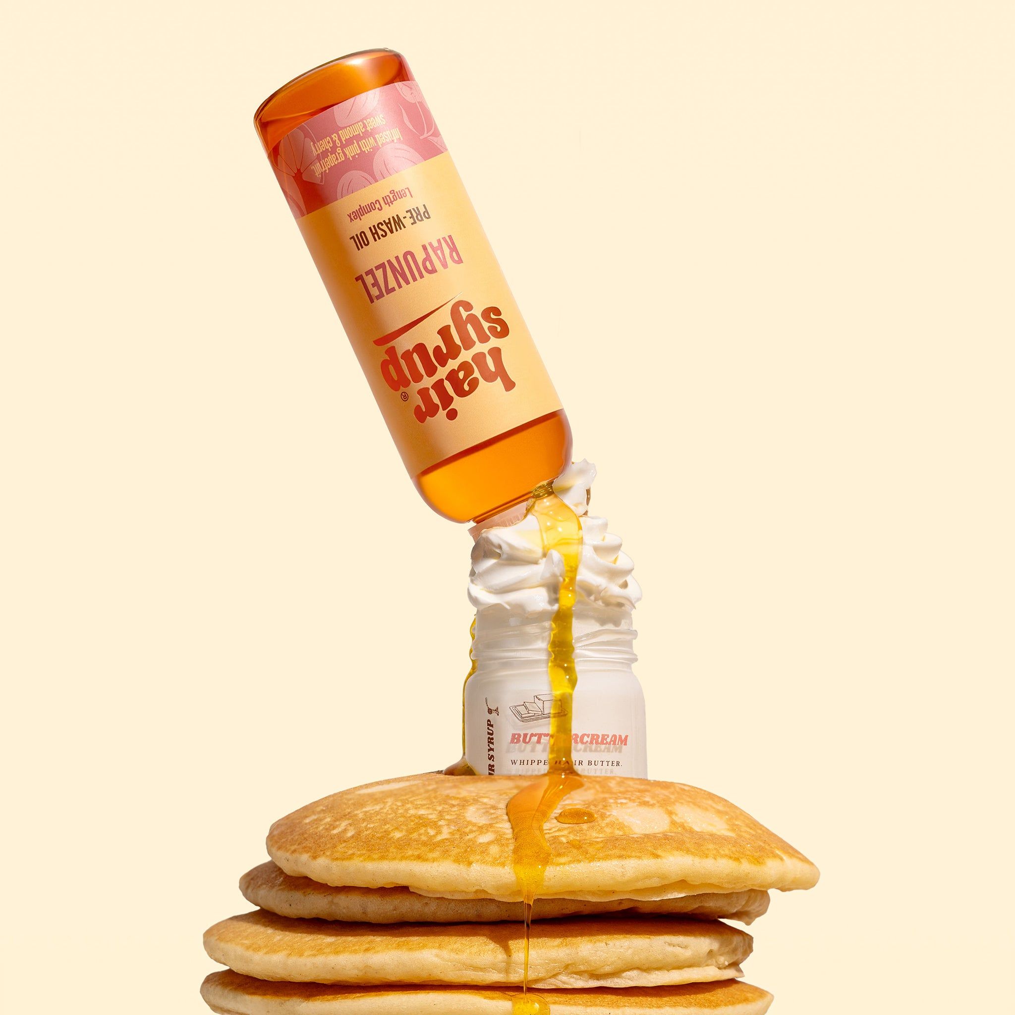Eine Flasche Hair Syrup Rapunzel, Pre-Wash Oil, gießt über einen Stapel Pfannkuchen. Gelbe Flüssigkeit fließt.