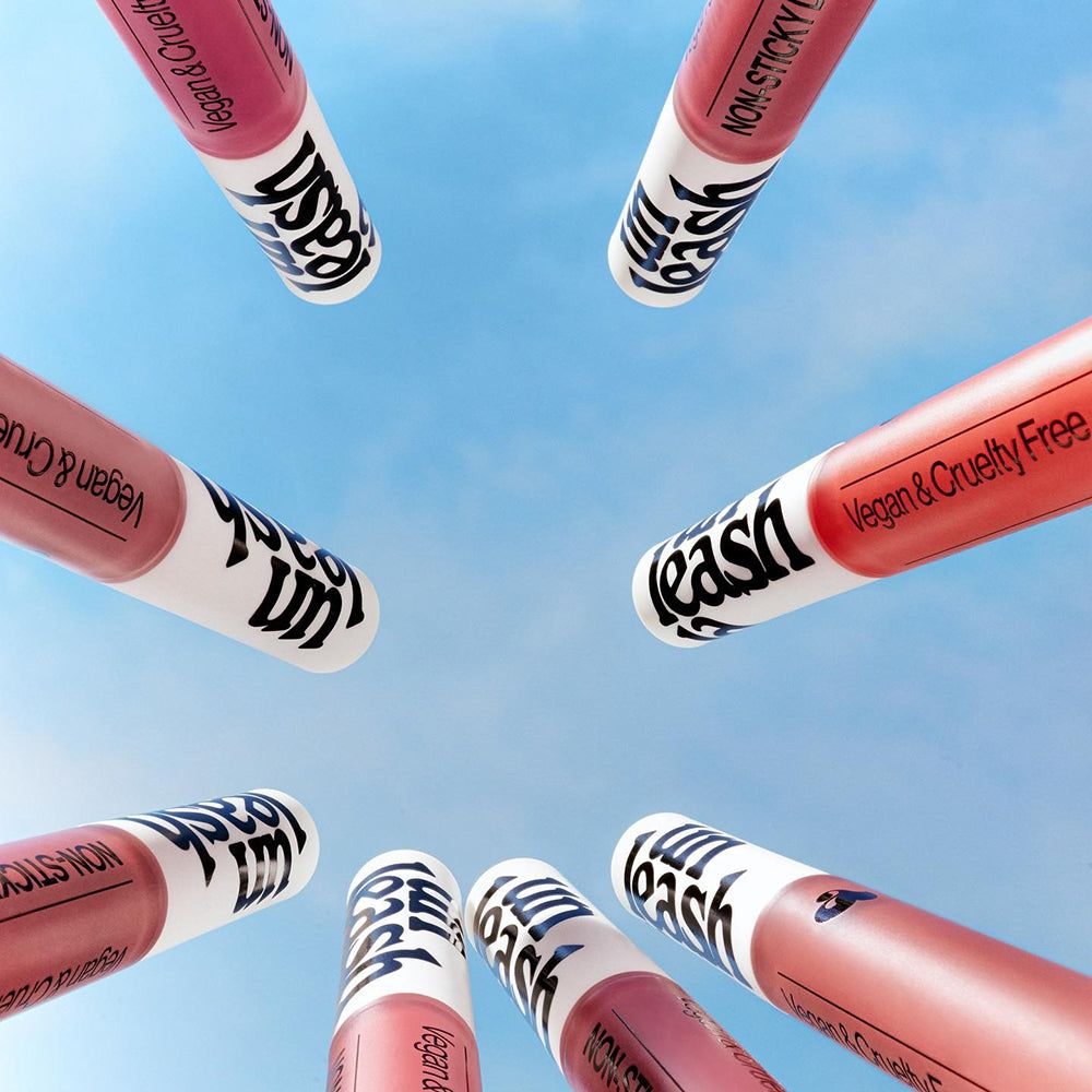 Mehrere Lippenstifte mit der Aufschrift 'Leash' und 'Vegan & Cruelty Free' auf weißem Hintergrund.