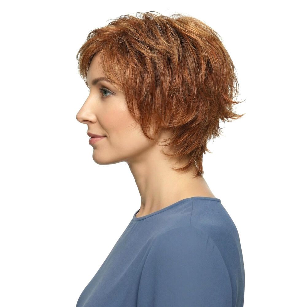 Profil einer Frau mit rotbrauner Perücke. Kurzes, gewelltes Haar. Sie trägt ein blaues Oberteil.