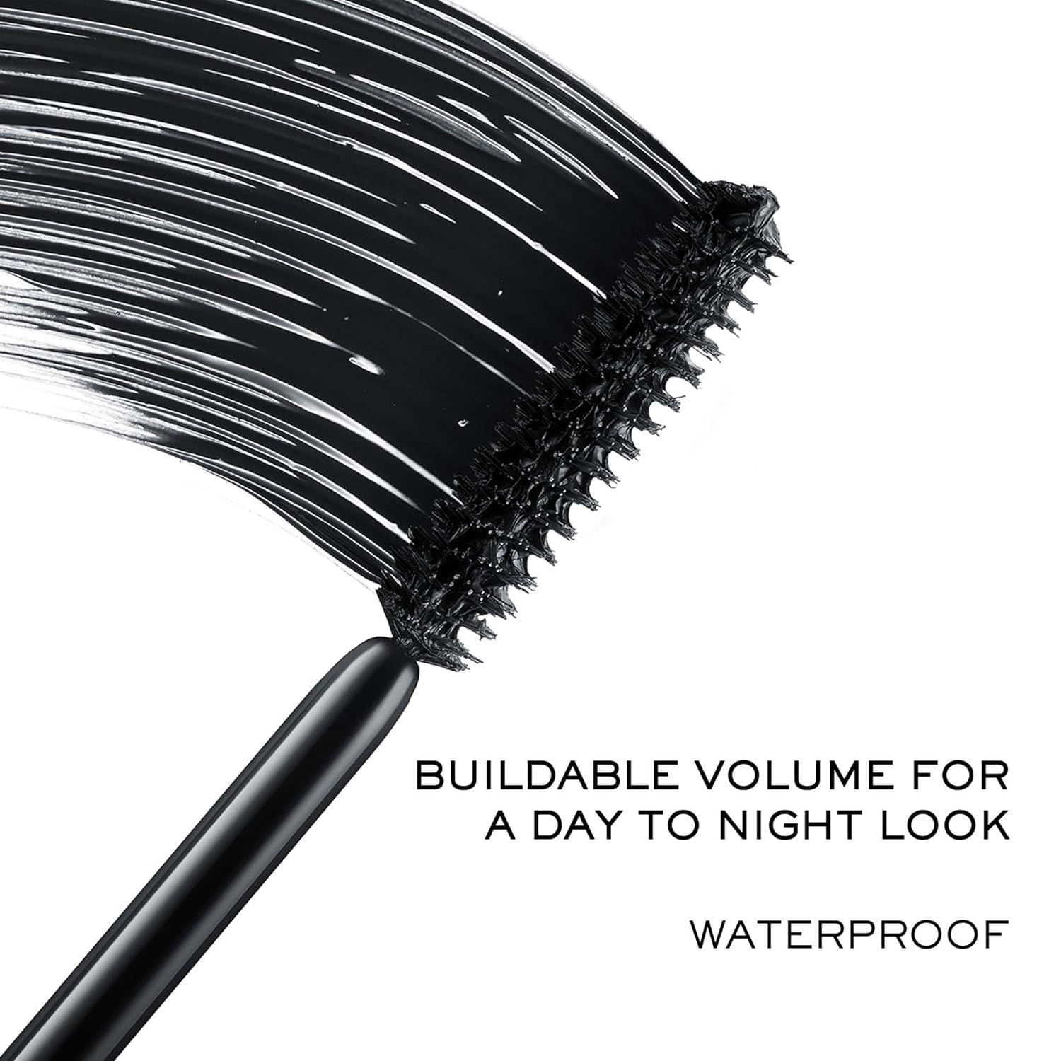 Mascarabürste mit schwarzer Mascara. Text: Buildable Volume for a day to night look. Waterproof.