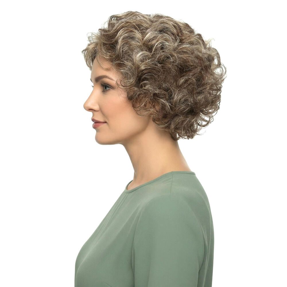 Perücke mit lockigem, blondiertem Haar. Die Frau trägt ein grünes Oberteil. Seitenansicht.