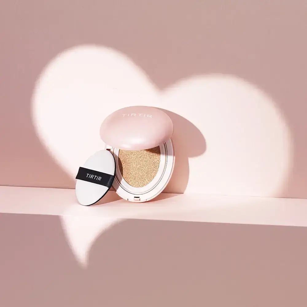 Rosa Make-up-Kompaktpuder mit Applikator. Das Produkt ist geöffnet. Ein Herzschatten wirft sich auf die Oberfläche.