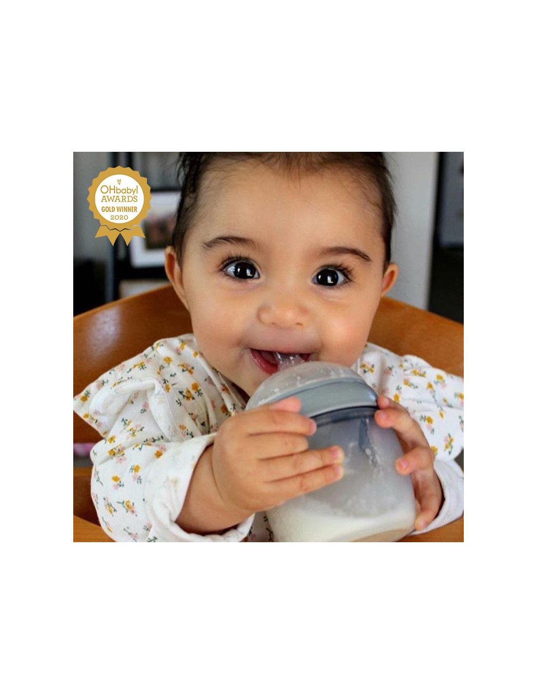 Baby trinkt aus einer Flasche. Gold-Award-Logo im Hintergrund.