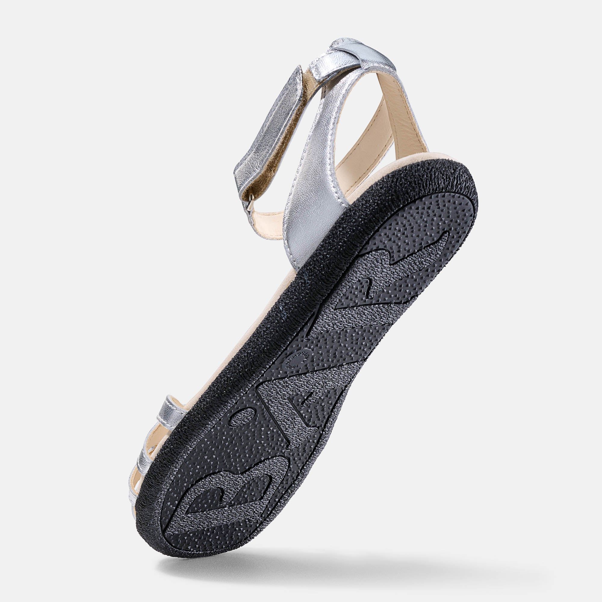Schwarze Sohle einer silbernen Sandale. Profilierte Unterseite. Marke BÄR.