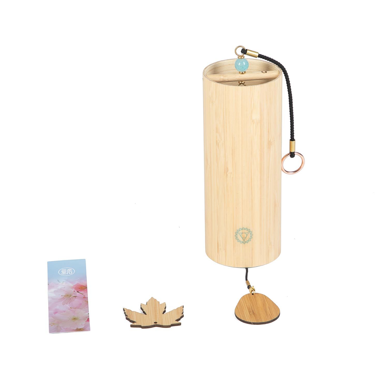 Zylindrische Klangspiel aus Bambus mit Holzblatt und Karte. Türkisfarbene Kugel und Ringe. Lotus-förmiges Holzstück.