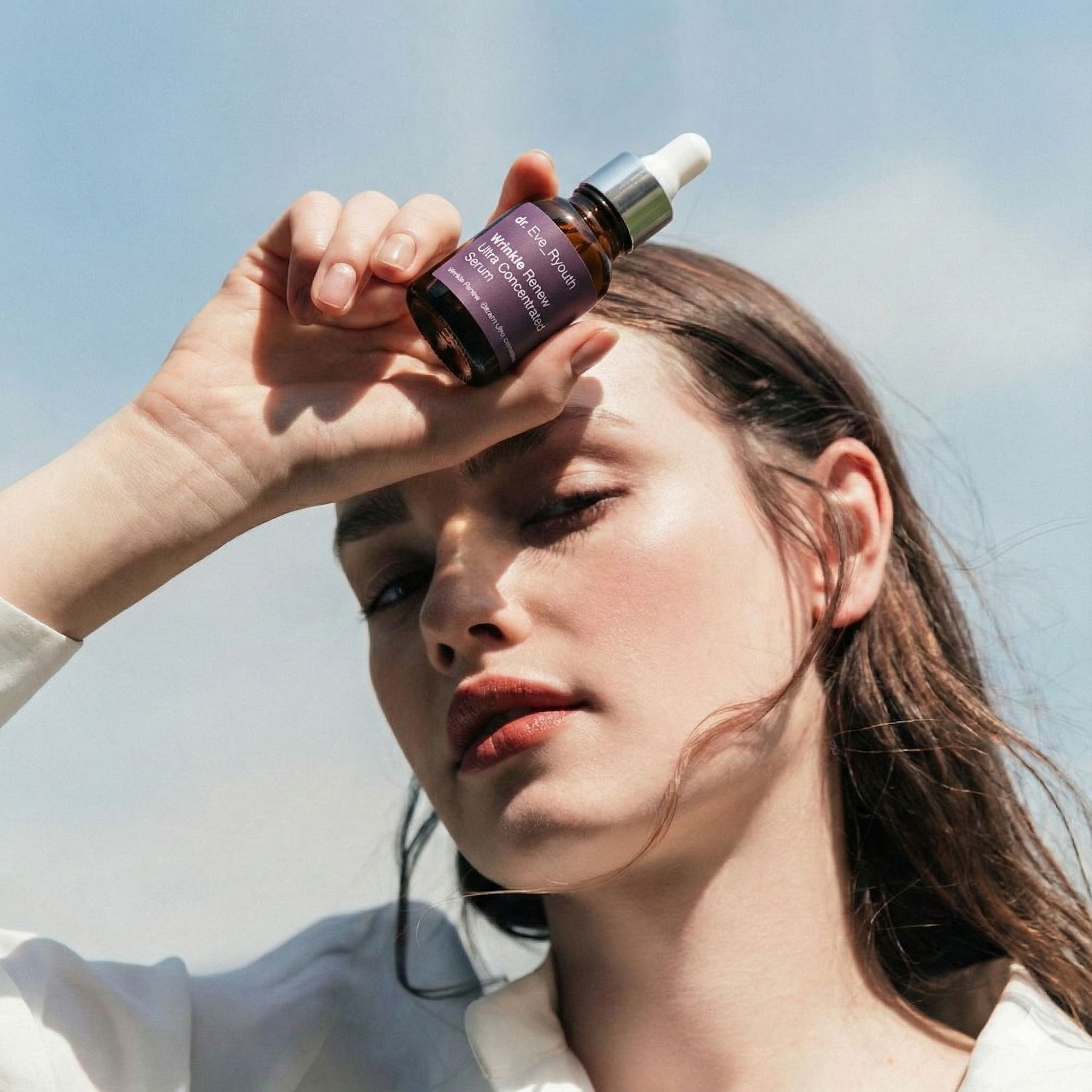 Frau hält Dr. Eve_Ryouth Faltenwiederherstellung Serum über der Stirn.