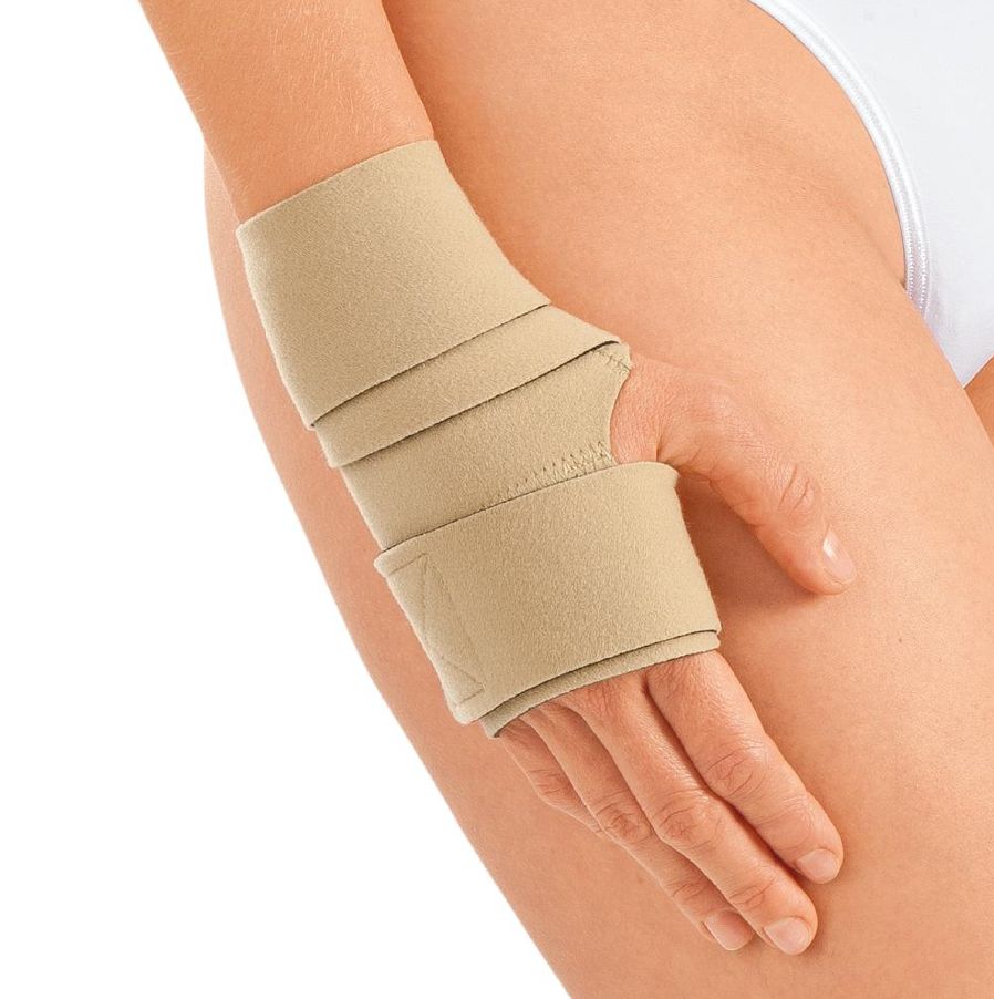 Beige Handteil Kompressionssystem am Handgelenk einer Person. Mehrere Klettverschlüsse. Nahaufnahme.