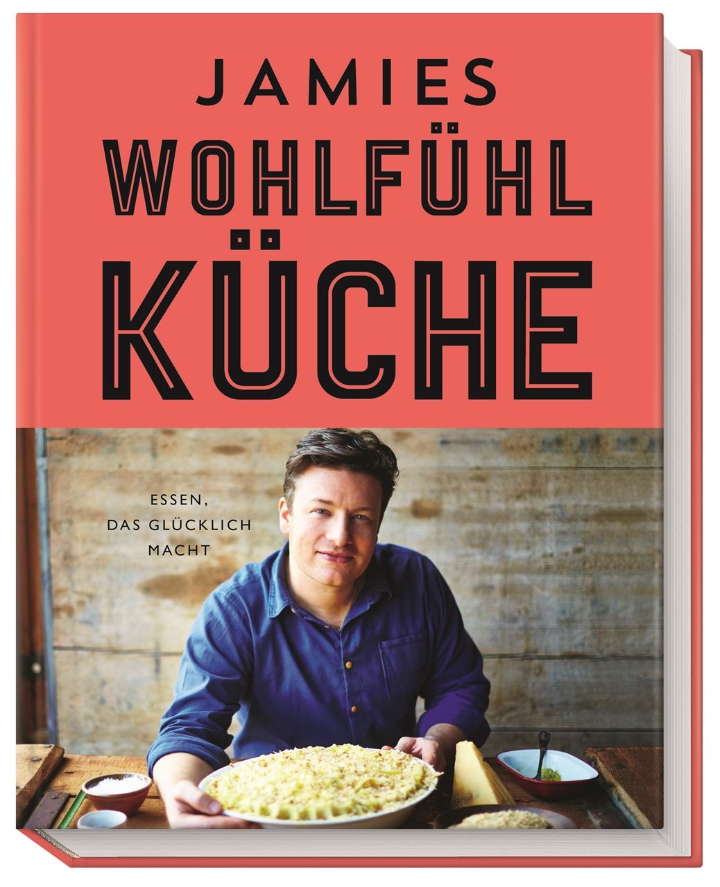 Buchcover von "Jamies Wohlfühlküche". Roter Hintergrund mit schwarzer Schrift. Foto von Jamie Oliver mit Essen.